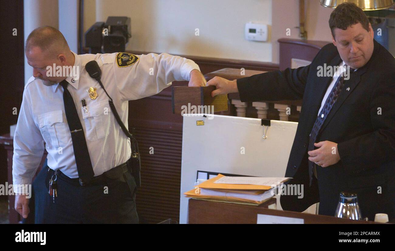 An unidentified court officer, left, draws a name from a box held by Court Clerk Scott Nickerson, right, to replace a juror in Christopher McCowen's murder trial Tuesday, Nov. 14, 2006, in Barnstable, Mass. A woman was thrown off the jury in the case of a murdered fashion writer Tuesday after she was recorded discussing media coverage of the case. (AP Photo/ Steve Heaslip, Pool) Banque D'Images