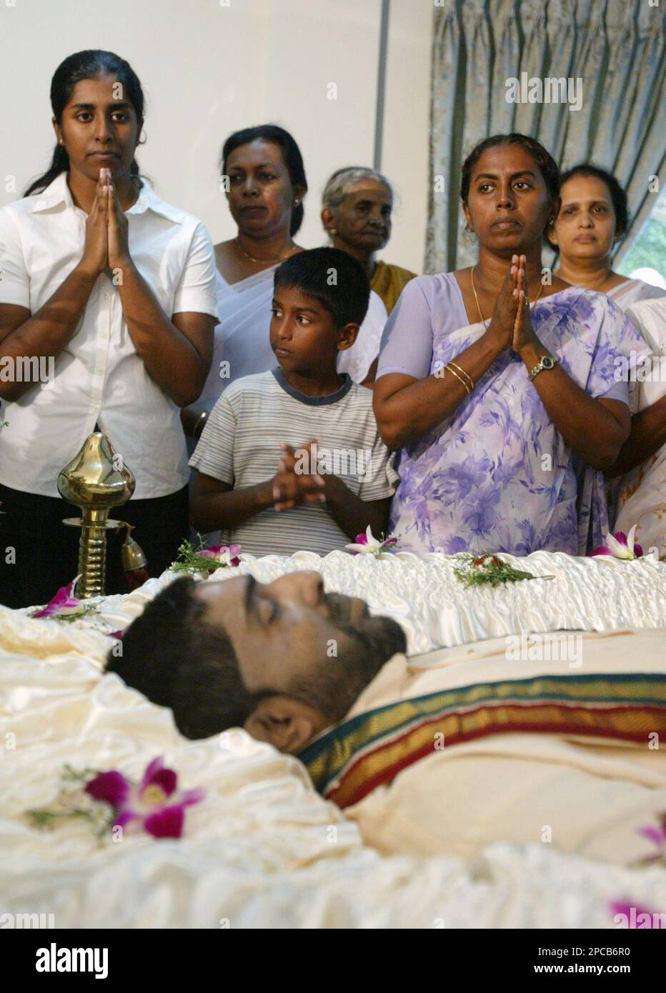 Family members of the slain ethnic Tamil parliamentarian Nadaraja Raviraj, from left in front row, daughter Praveena, son Yudeshran, and wife Sashi, pray near his body in Colombo, Sri Lanka, Saturday, Nov. 11, 2006. Raviraj, a member of the Tamil National Alliance, widely believed to be a proxy of the Tamil Tigers, was gunned down by unknown gunmen Friday when he was traveling for work in Colombo. (AP Photo/Eranga Jayawardena) Banque D'Images
