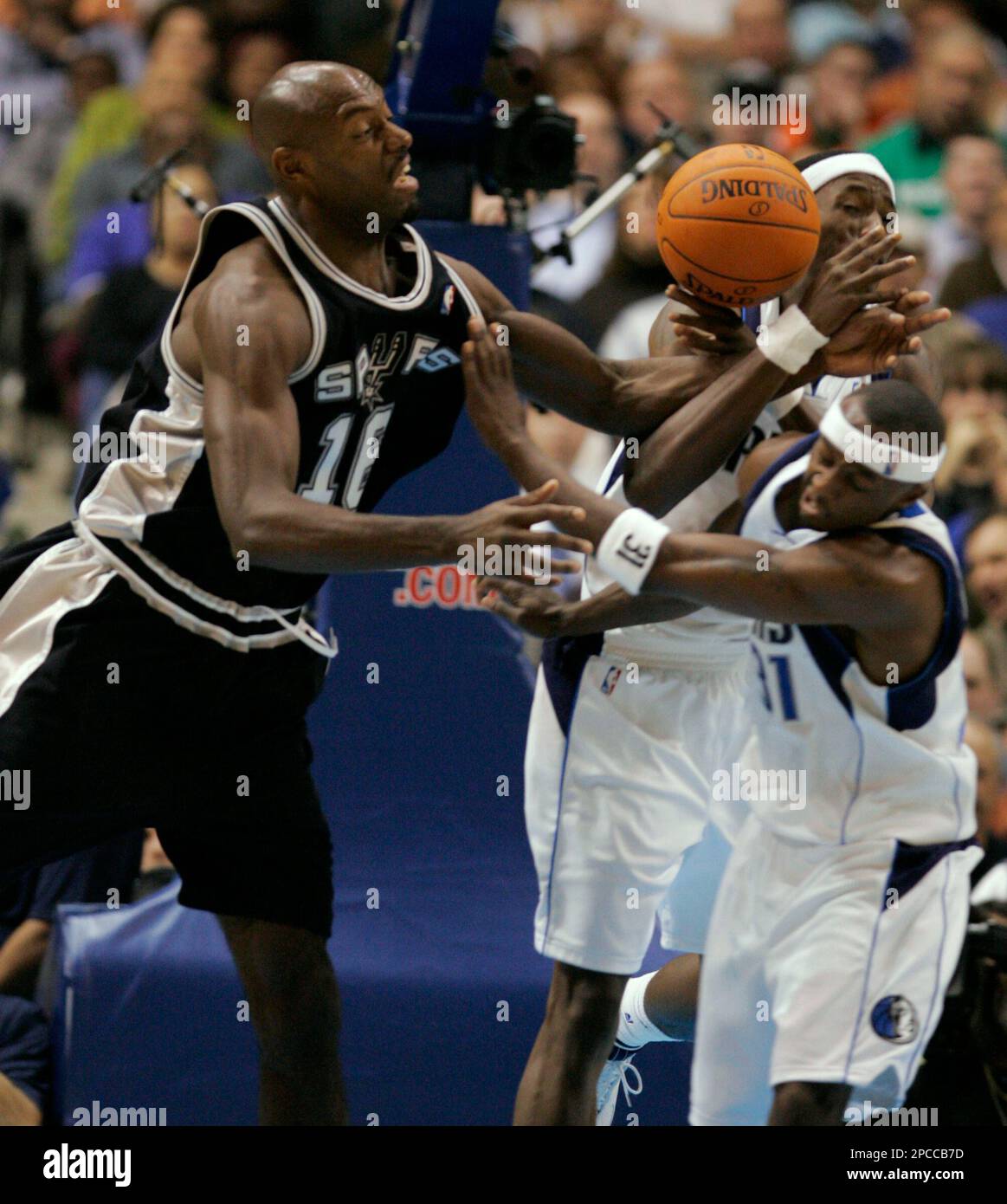 San Antonio Spurs center Francisco Elson (16), from the Netherlands, reaches for a rebound against Dallas Mavericks' Jason Terry (31) and Josh Howard in the second half of their basketball game in Dallas, Thursday, Nov. 2, 2006. San Antonio won, 97-91. (AP Photo/Donna McWilliam) Banque D'Images