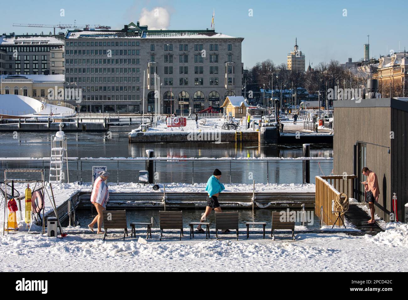 Les gens autour de la piscine d'eau froide de la mer d'Allas lors d'une journée d'hiver ensoleillée dans le quartier de Katajanokka à Helsinki, en Finlande Banque D'Images