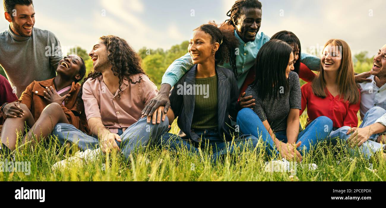 Un groupe d'amis joyeux et divers, y compris des étudiants et des voyageurs internationaux, se livrent à des activités de plein air et à la détente dans une ville dynamique p Banque D'Images