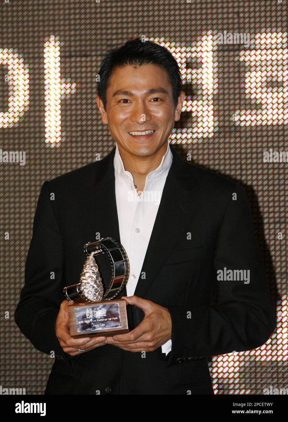 Hong Kong movie star Andy Lau, holding the trophy, is awarded this year as Asian Filmmaker of the Year at the 11th Pusan International Film Festival in Busan, South Korea, Friday, Oct. 13, 2006. The veteran Hong Kong actor-singer is being honored as the Asian film maker of the year for his efforts to promote Asian cinema. The 45-year-old Lau has worked with young directors and invested in the independent film by Hong Kong director Fruit Chan, "Made in Hong Kong," in 1997. (AP Photo/Kin Cheung) Banque D'Images
