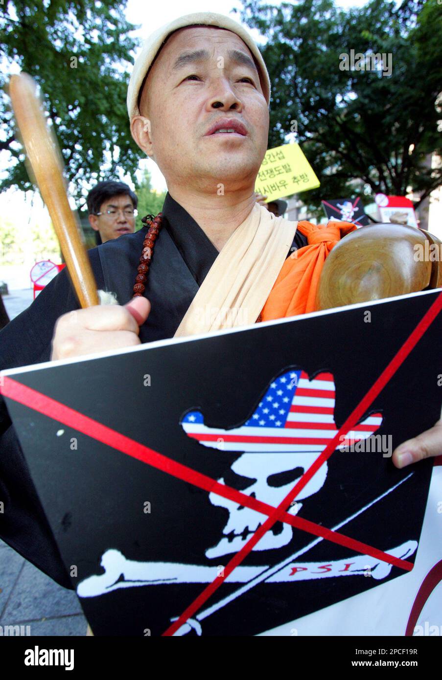 A South Korean Buddhist monk beats a wooden gong during an anti-U.S. rally demanding talks between the United States and North Korea near the U.S. embassy in Seoul, Thursday, Oct. 12, 2006. The United States hopes to pass a new draft U.N. Security Council resolution on Friday to punish North Korea over its claimed nuclear test, U.S. Ambassador John Bolton said.(AP Photo/Ahn Young-joon) Banque D'Images