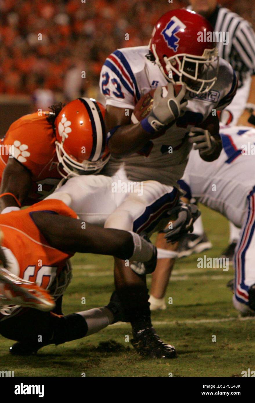 Louisiana Tech's Patrick Jackson (23) gets stopped for a loss of yardage by Clemson's Phillip Merling(94) bottom and Nick Watson(32) during the first half of their football game Saturday, Sept. 30, 2006, at Memorial Stadium in Clemson, S.C. (AP Photo/Mary Ann Chastain) Banque D'Images