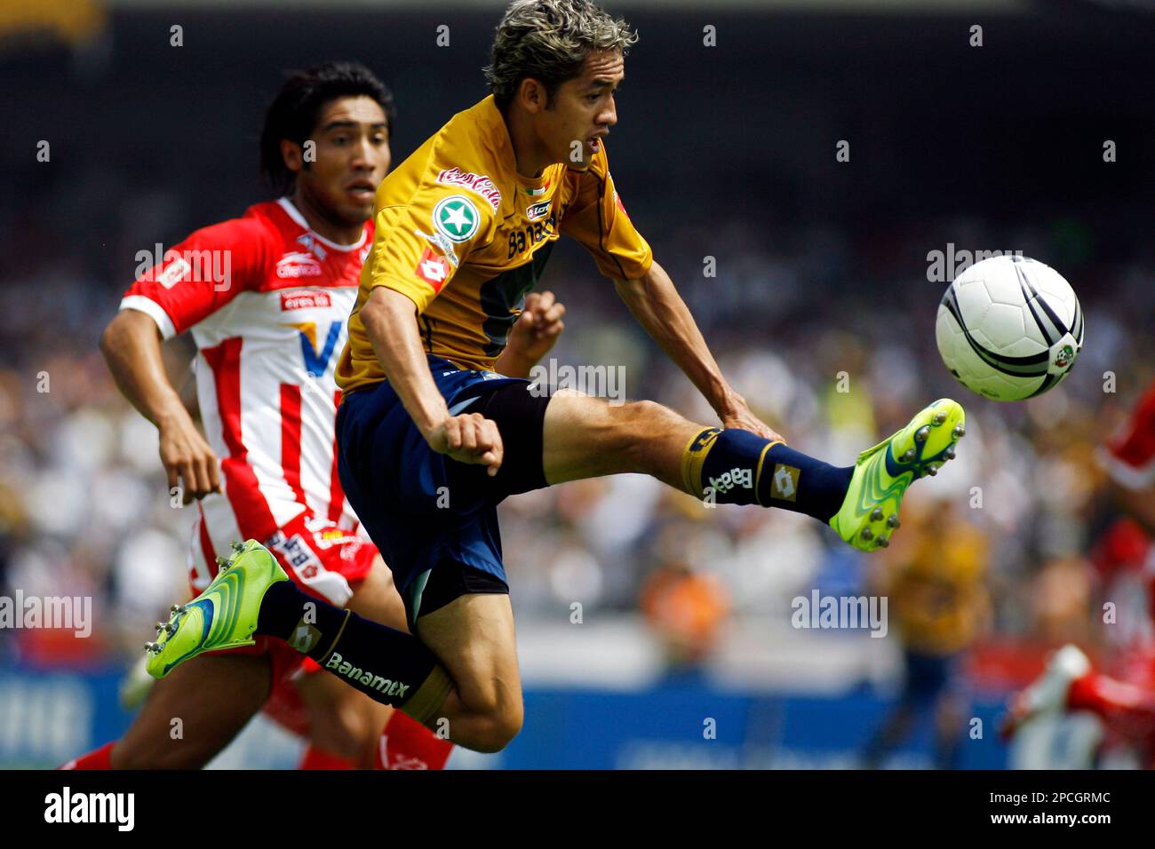Pumas' soccer player Jose Luis Lopez, front, kicks the ball as Necaxa's Mario Perez challanges at the University stadium in Mexico City, Mexico, on Sunday, September 24 , 2006, during their Mexican league championship soccer match. ( AP Photo/ Claudio Cruz) Banque D'Images