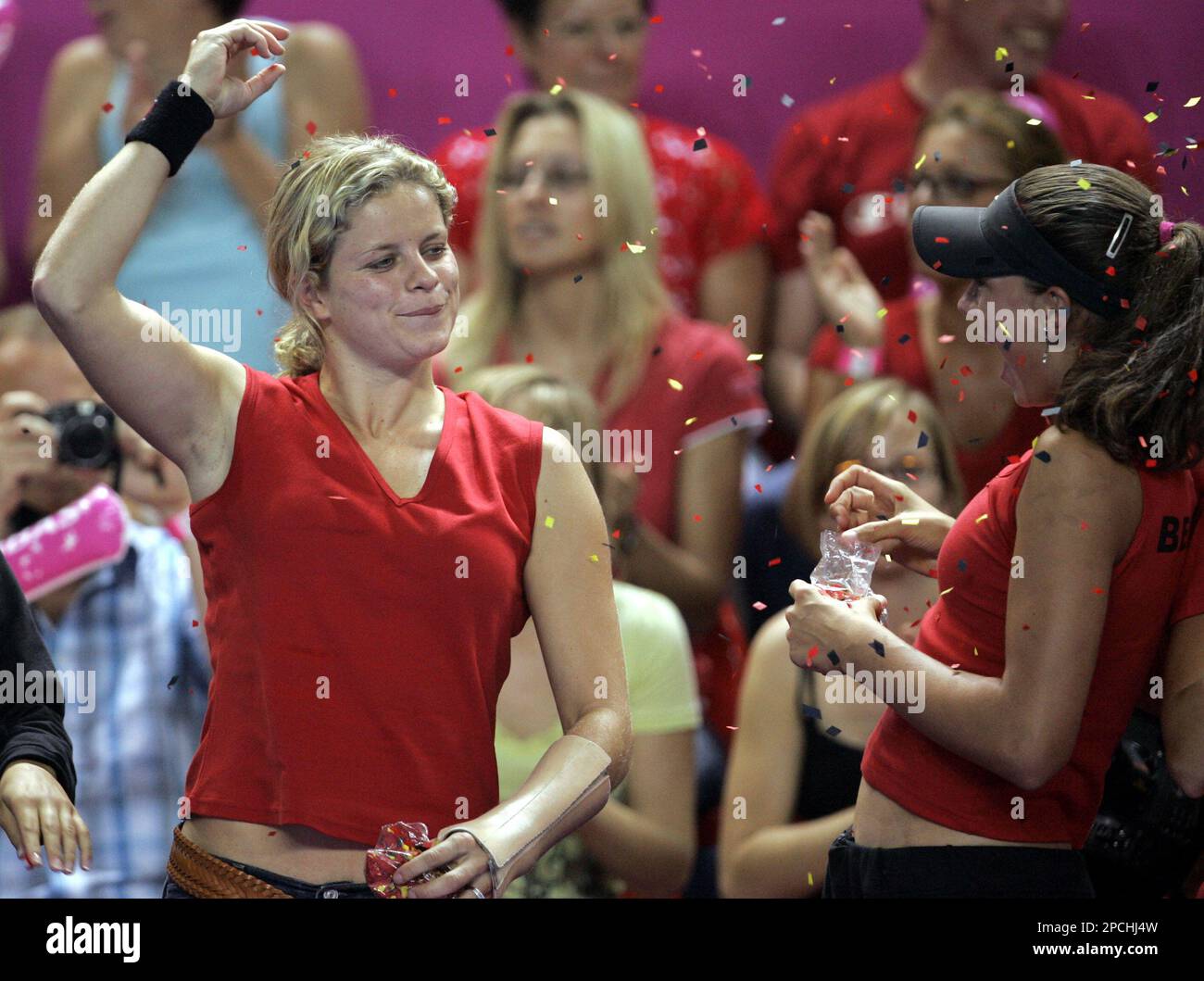 Belgium's injured Kim Clijsters, left, celebrates after teammate Justine Henin-Hardenne beat Italy's Francesca Schiavone on the second day of the Fed Cup tennis final in Charleroi, Belgium, Sunday Sept. 17, 2006. Henin won 6-4, 7-5. (AP Photo/Yves Logghe) Banque D'Images