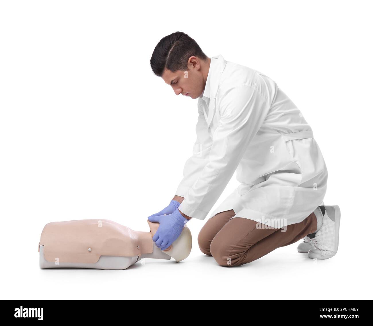 Médecin en uniforme pratiquant les premiers soins sur un mannequin sur fond blanc Banque D'Images