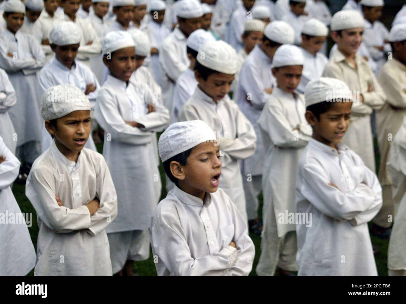 Students of an Islamic school sing an Indian patriotic song during their routine prayer assembly on the outskirts of Jammu, India, Thursday, Sept. 7, 2006. The centennial of India's controversial national song Vande Mataram, which means in Hindi "I bow to thee, mother," on Thursday sharply divided Hindu nationalists and Sikh and Muslim leaders after the federal government in August ordered the first two verses to be sung in schools to mark 100 years of its adoption as the country's national song by the Indian National Congress on Sept. 7, 1906. Last month Muslim clerics asked their followers n Banque D'Images