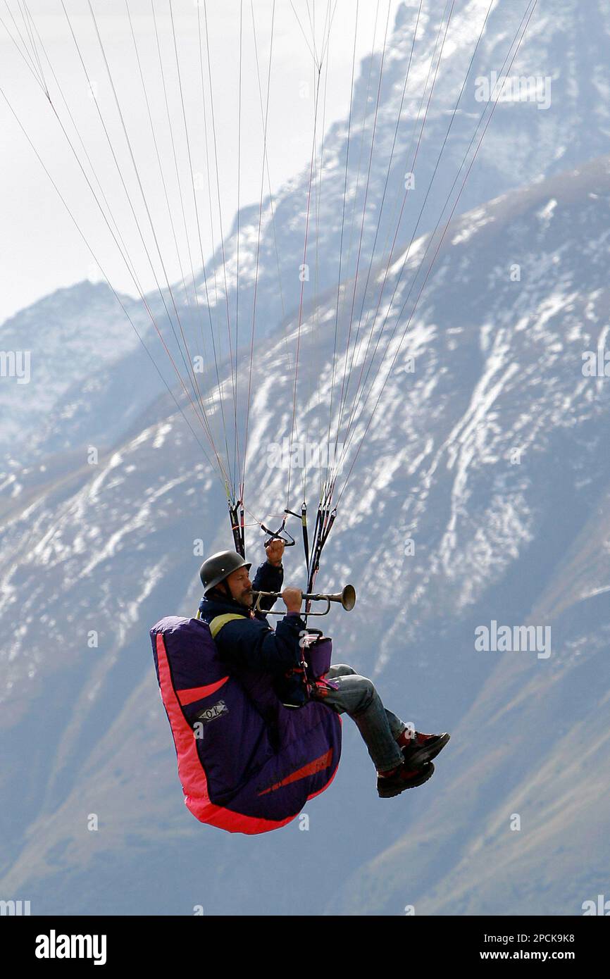 A member of carnival brass band "Bellalp Hexe" plays a trumpet while paragliding, during a world record attempt in Fiesch, South-Western Switzerland, Saturday, September 2, 2006. The goal of the day was to get as many musicians as possible in the air simultanously, piloted by expierienced tandem paragliding pilots. The task, attempted with 21 paragliders, goes into the guiness book of records. Fiesch is a well known meca for paragliding in the Swiss alps. (KEYSTONE/Olivier Maire) Banque D'Images