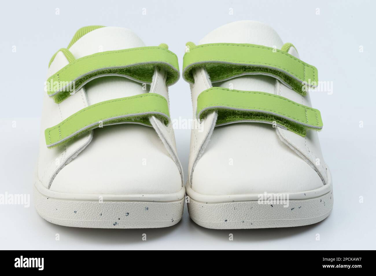 Paire de chaussures blanches pour enfant avec vue avant velcro isolée sur un arrière-plan de studio Banque D'Images