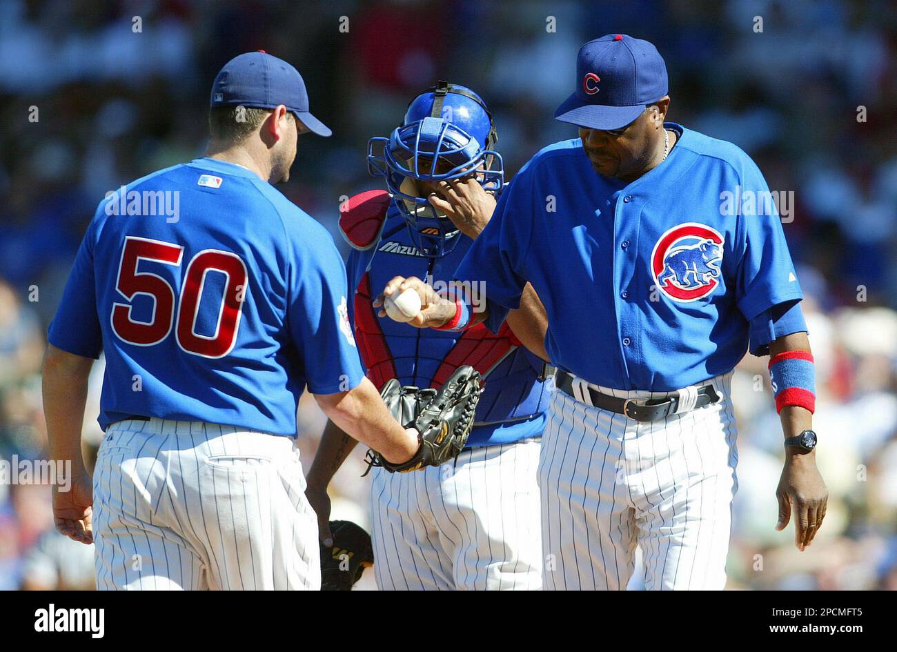 Chicago Cubs manager Dusty Baker, right, hands the ball off to relief pitcher Will Ohman(50) as catcher Henry Blanco looks on during the ninth inning of a National League baseball game against the St. Louis Cardinals in Chicago on Sunday, Aug. 20, 2006. The Cardinals beat the Cubs, 5-3. (AP Photo/Joseph Oliver) Banque D'Images