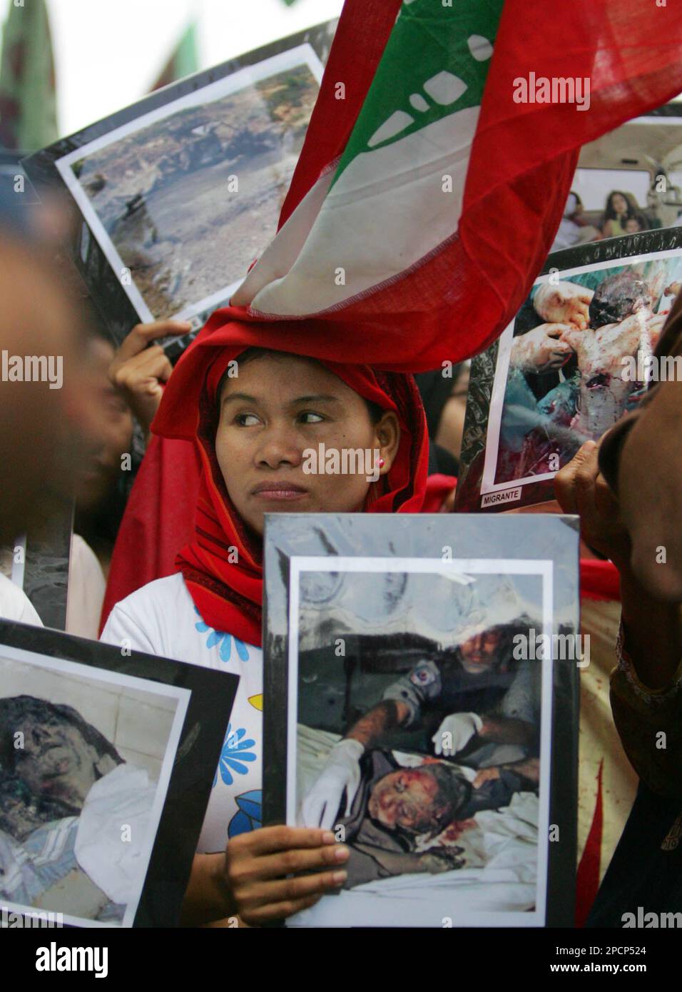 A Lebanese flag falls on the head of a Muslim protester as they display pictures of alleged victims of Israeli bombing during a rally Friday, Aug. 4, 2006 in Manila. A Muslim political party called on all Muslim nations to unite and condemned Israeli attack on Lebanon and on Palestinian people and the entire Muslim community. (AP Photo/ Pat Roque) Banque D'Images