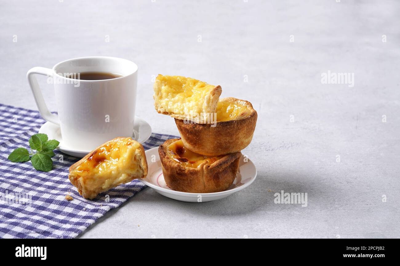 Tartes typiques de crème portugaise - pastel de Nata et tasse de café sur table blanche sur serviette bleue, espace de copie Banque D'Images