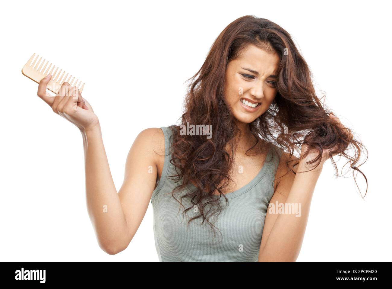 Problèmes de cheveux. Une femme qui se bat avec ses cheveux tenant un peigne. Banque D'Images