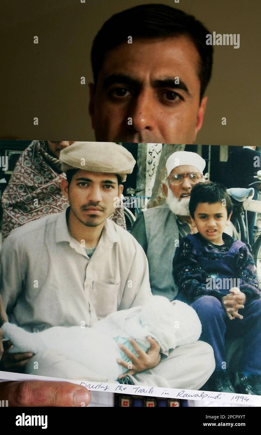 **FILE** Amjad Hussain holds up a 1993 photograph of his brother Tahir ...