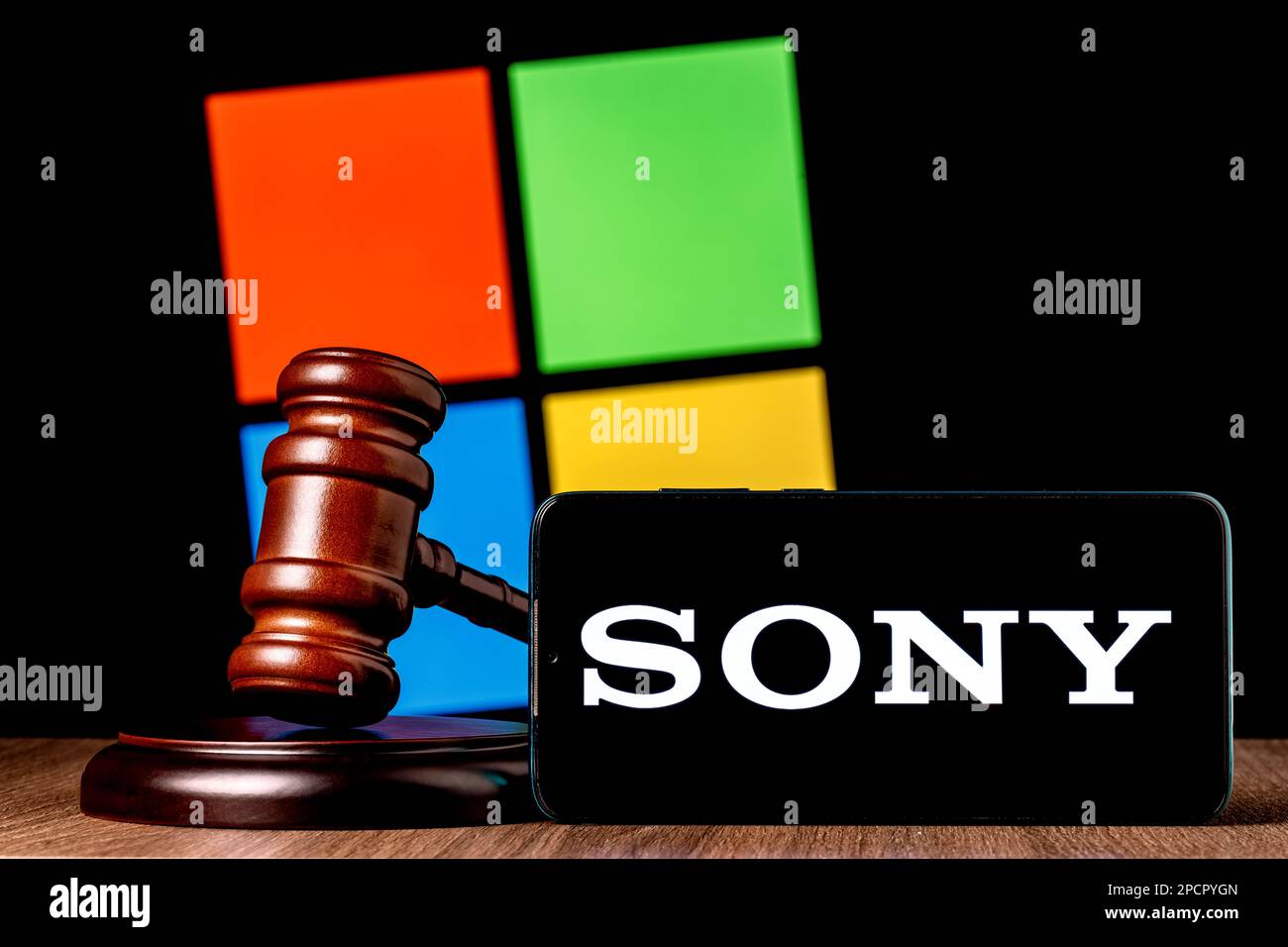 Gavel et smartphone avec logo SONY à l'écran sur la table, sur fond du logo de la société Microsoft. Le concept d'essai entre Sony et Microsoft. Banque D'Images