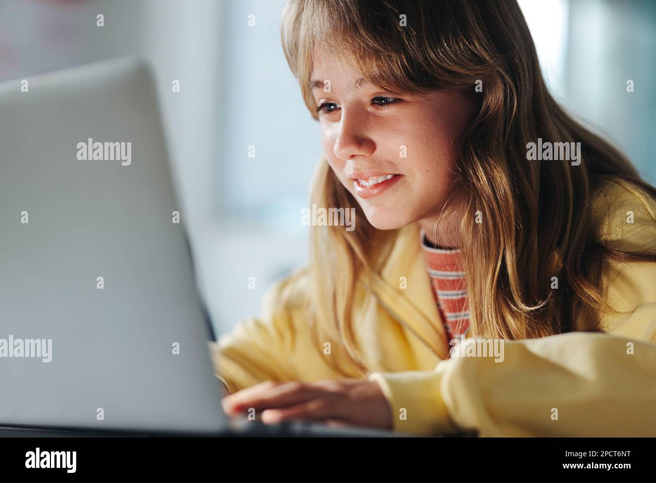 Jeunes étudiantes qui apprennent à programmer avec un ordinateur portable dans une classe. En regardant son écran, elle explore le monde numérique avec sa morue nouvellement acquise Banque D'Images