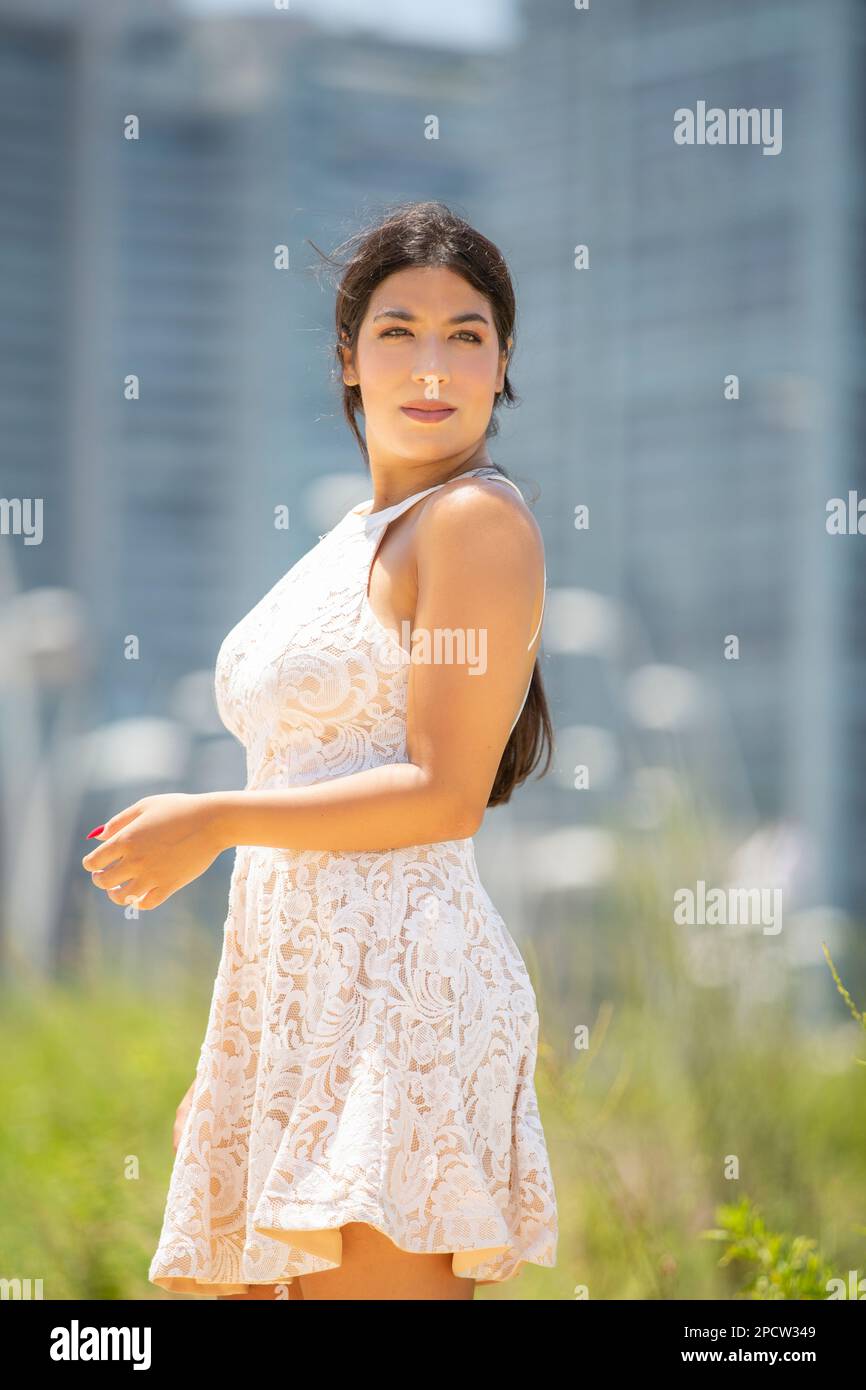 Belle jeune femme en robe blanche debout à l'extérieur en regardant loin Banque D'Images