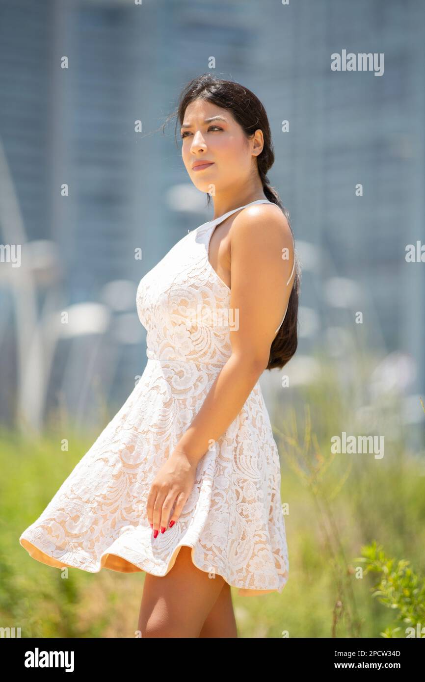 Belle jeune femme en robe blanche debout à l'extérieur en regardant loin Banque D'Images