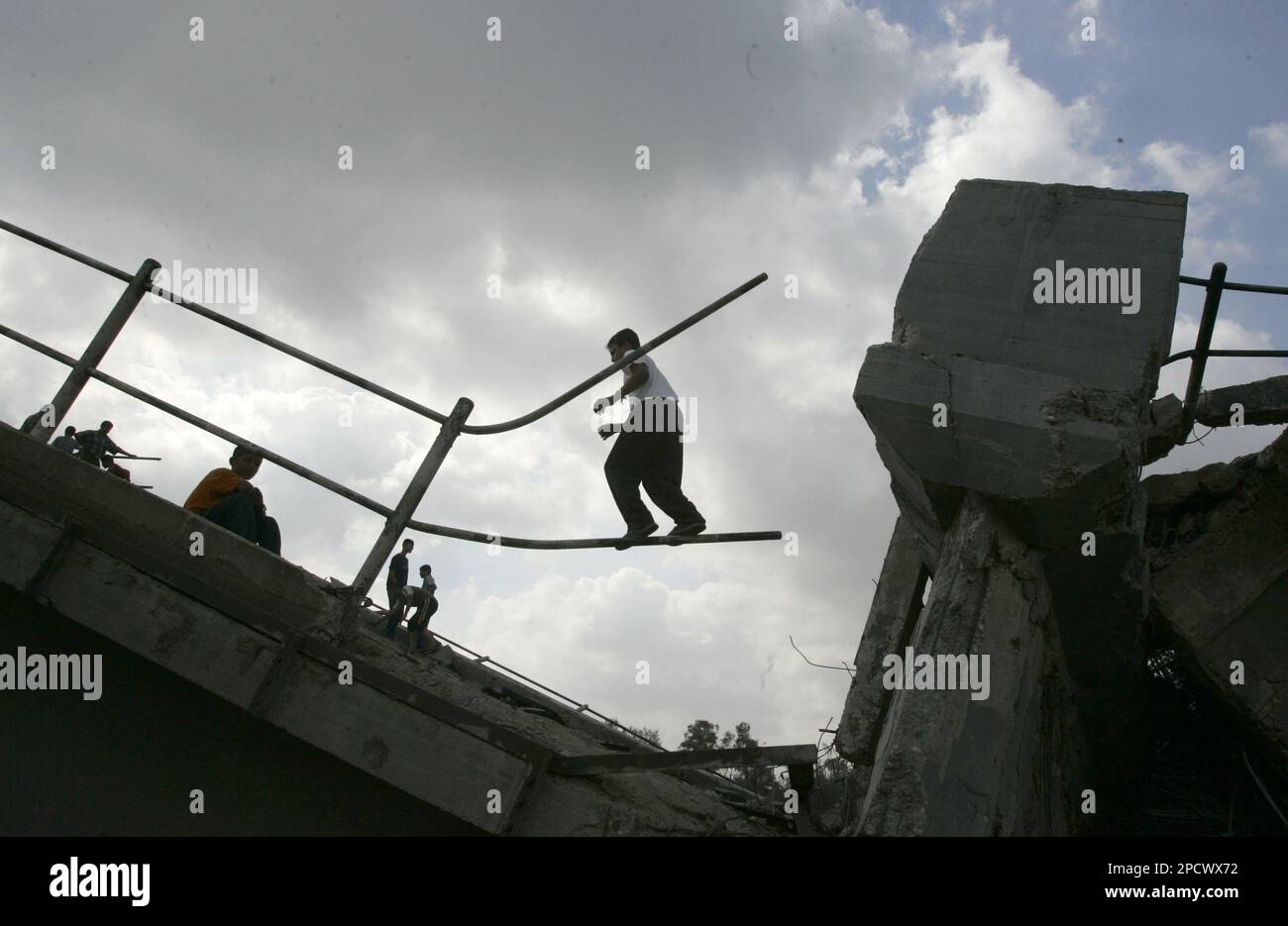 Palestinian children play on a bridge destroyed early morning by Israeli warplanes on a main road in the northern Gaza Strip, near Gaza City Wednesday June 28, 2006. Israeli tanks and troops entered southern Gaza and planes attacked three bridges and a power station, knocking out electricity in most of the coastal strip early Wednesday and stepping up the pressure on Palestinian militants holding captive a 19-year-old Israeli soldier. (AP Photo/Hatem Moussa) Banque D'Images