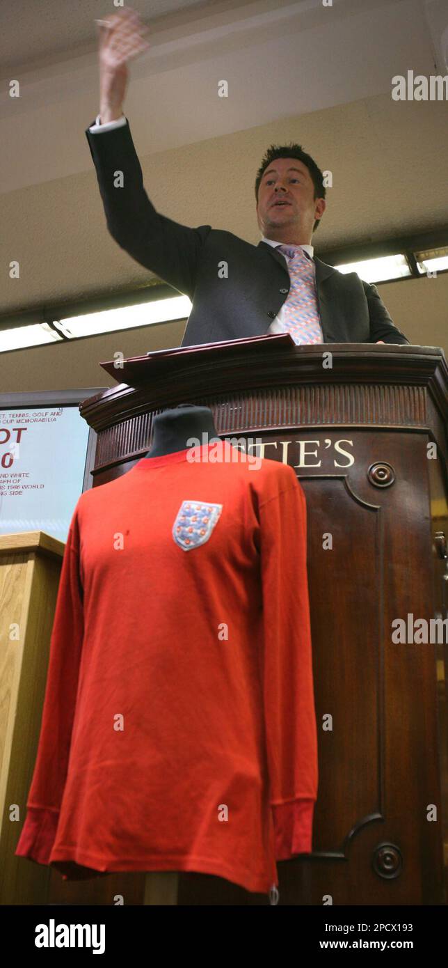 Auctioneer David Convery takes bids on a 1966 England world cup final football shirt worn by George Cohen during its auction at a London auction house, Tuesday June 27, 2006. Cohen swapped shirts with Germany's Lothar Emmerich after the final in 1966 Emmerich's family have kept the shirt to this day. The shirt sold for 38,400 pounds ($US 71,000, euros 55,700) to an anonymous bidder. (AP Photo / Christopher Pledger) Banque D'Images