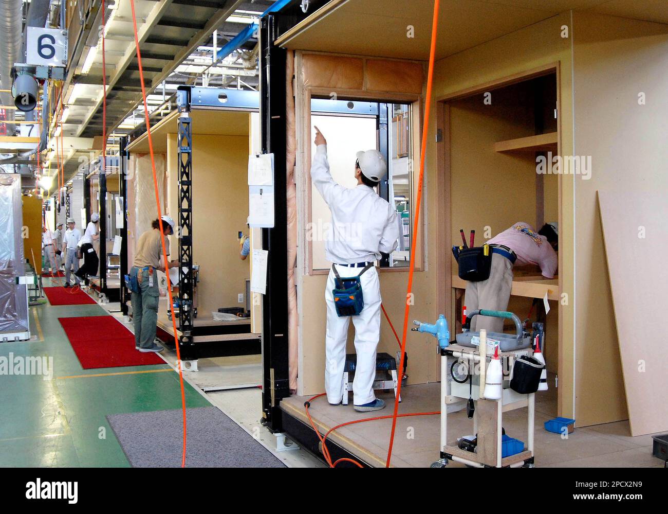 Workers are busy in cubicles that are parts of homes, complete with ...