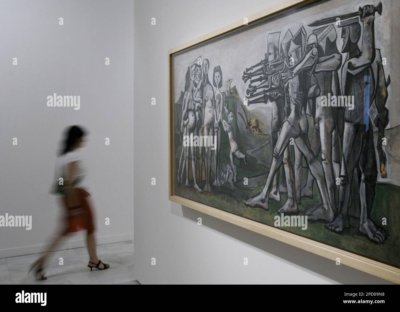 A visitor crosses in front Spanish artist Pablo Picasso's painting "Massacre in Korea" at Madrid's Reina Sofia museum in Madrid, Tuesday, June 6, 2006. Spain celebrates the 25th anniversary of the return of "Guernica" this year and the 125th anniversary of Picassos birth. The painting depicts the German bombing of this small Basque town during the Spanish Civil War. (AP Photo/Bernat Armangue) Banque D'Images