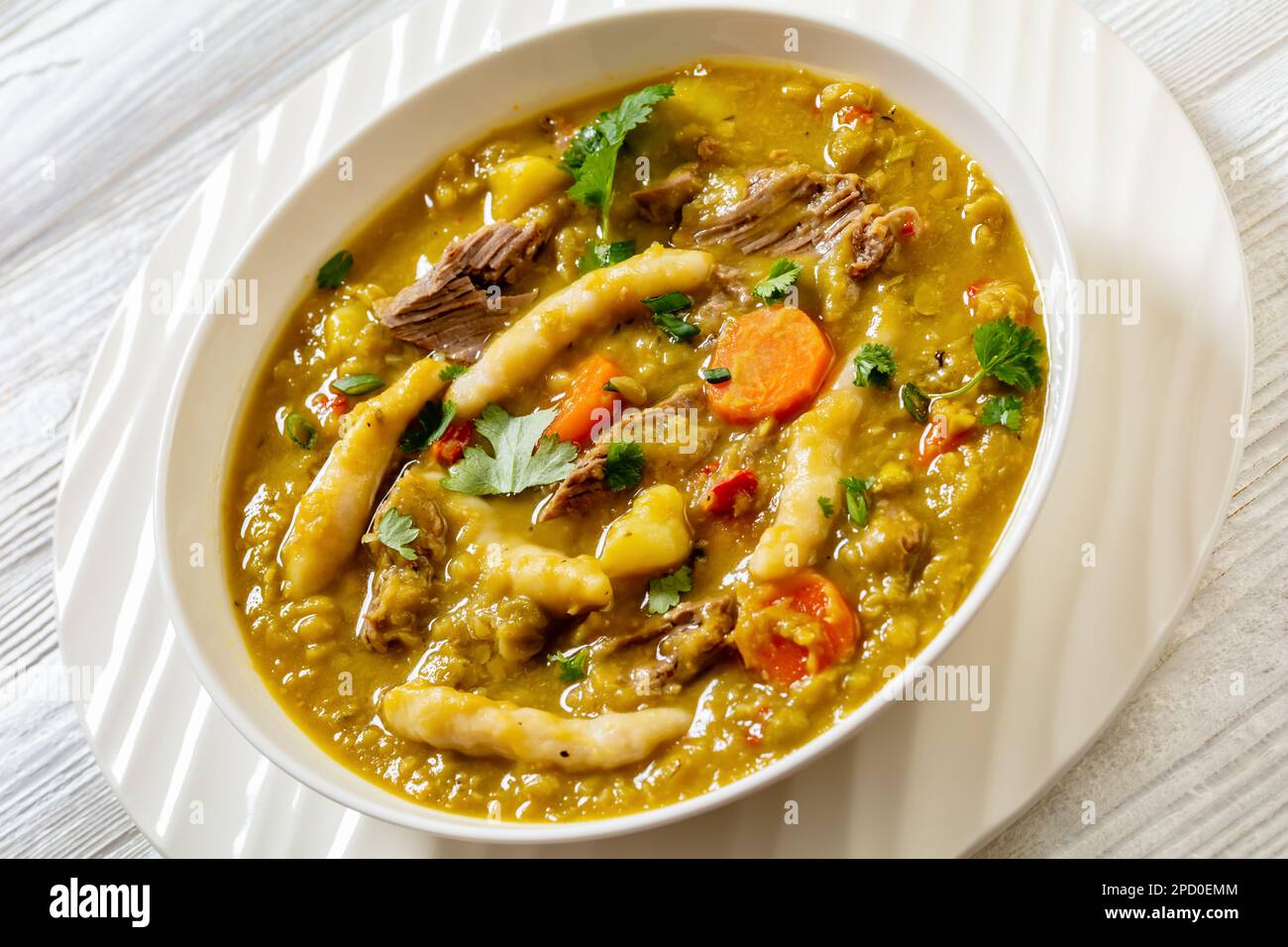 petits pois, soupe de petits pois avec boulettes, légumes et bœuf dans un bol blanc sur table blanche, cuisine jamaïcaine, gros plan Banque D'Images