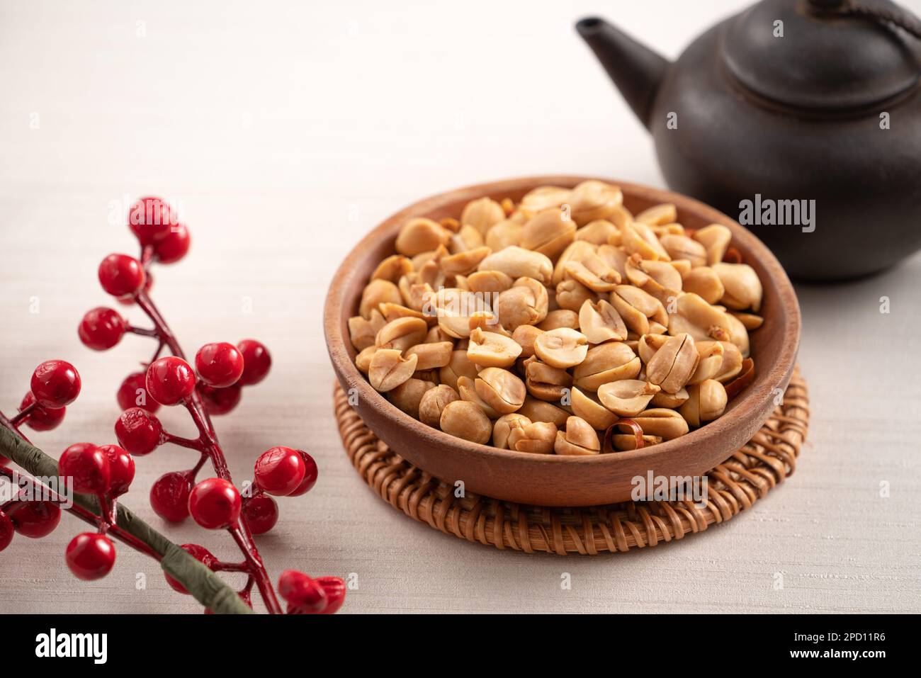 Grains de cacahuètes aromatisés épicés dans un bol sur fond de table blanc. Banque D'Images