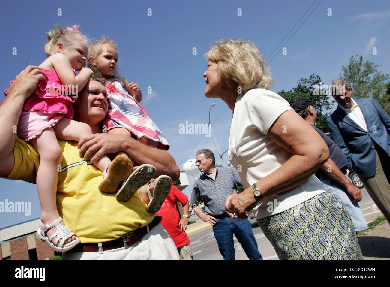 Iowa first lady Christie Vilsack talks to Cortney Graber as he holds his daughter, Elizabeth Graber, 3, and her cousin, Laney Graber, 3, all of Mount Pleasant, before the Memorial Day service Monday, May 29, 2006, at the Iowa Veteran's Memorial at the Henry County Courthouse in Mount Pleasant, Iowa. Gov. Tom Vilsack is seen in background at right. (AP Photo/The Hawk Eye, Scott Morgan) Banque D'Images