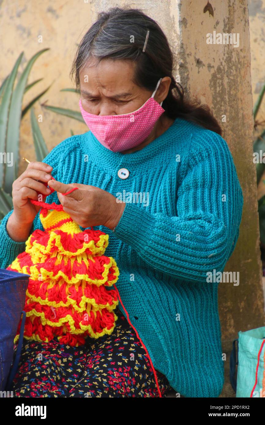 Femme crotcheting avec une aiguille à tricoter photographiée à Dalat, Vietnam Banque D'Images