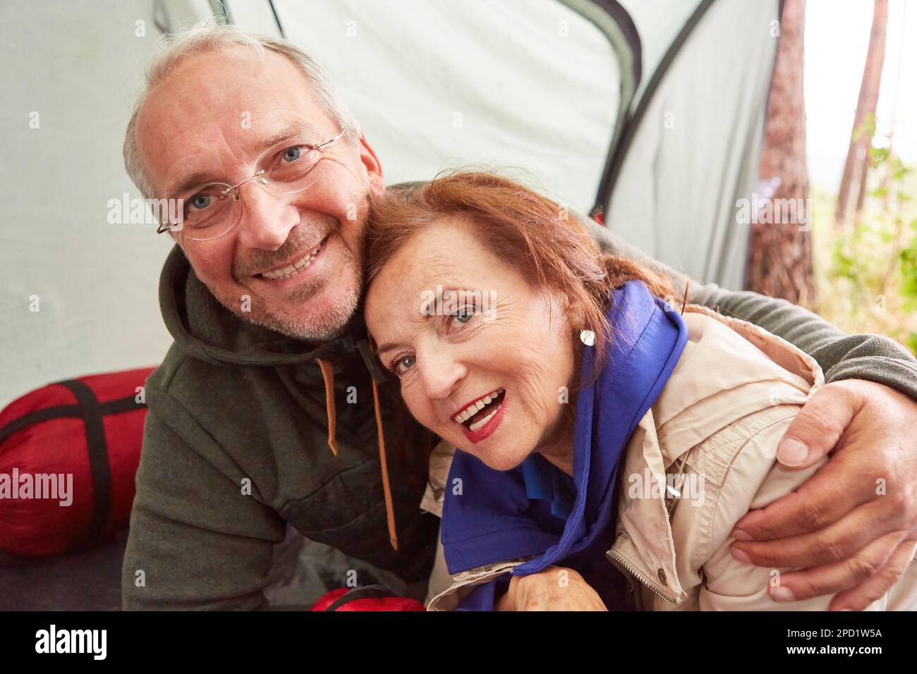 Portrait d'un couple senior heureux se relaxant dans une tente de camping en forêt pendant les vacances Banque D'Images Portrait d'un couple senior heureux se relaxant dans une tente de camping en forêt pendant les vacances Banque D'Images