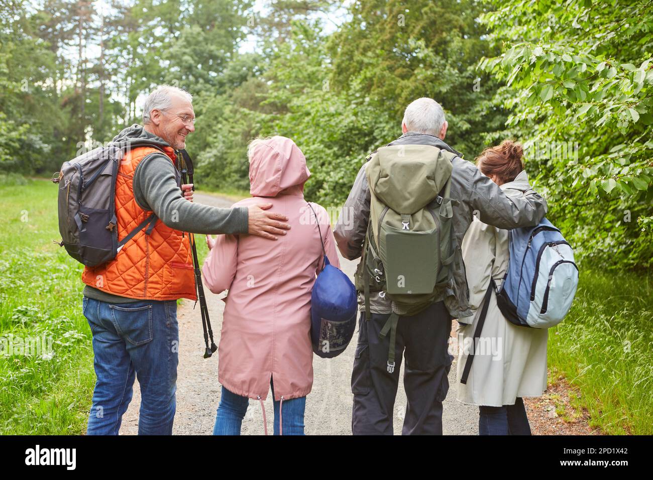 Vue arrière des hommes et des femmes âgés marchant ensemble dans la forêt pendant les vacances Banque D'Images