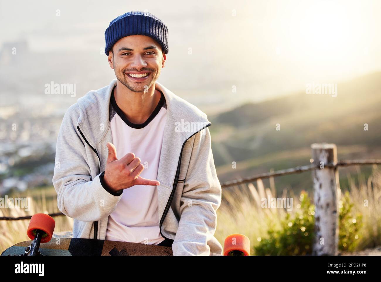 Sourire, portrait de skateboarder avec geste de la main de Shaka et passe-temps et compétence de skateboarding en montagne. Liberté, plaisir et visage de cool heureux gen z man Banque D'Images