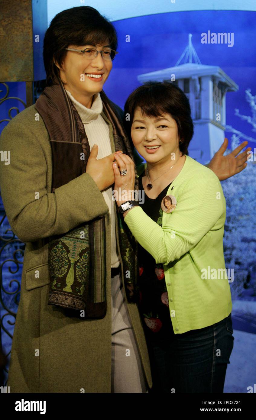 A Japanese fan of South Korean actor Bae Yung-joon poses beside his new unveiled wax figure which is displayed at Madame Tussauds in Hong Kong Monday May 15, 2006. The wax figure of Bae is the first Korean star displaying in the Madame Tussauds. (AP Photo/Kin Cheung) Banque D'Images
