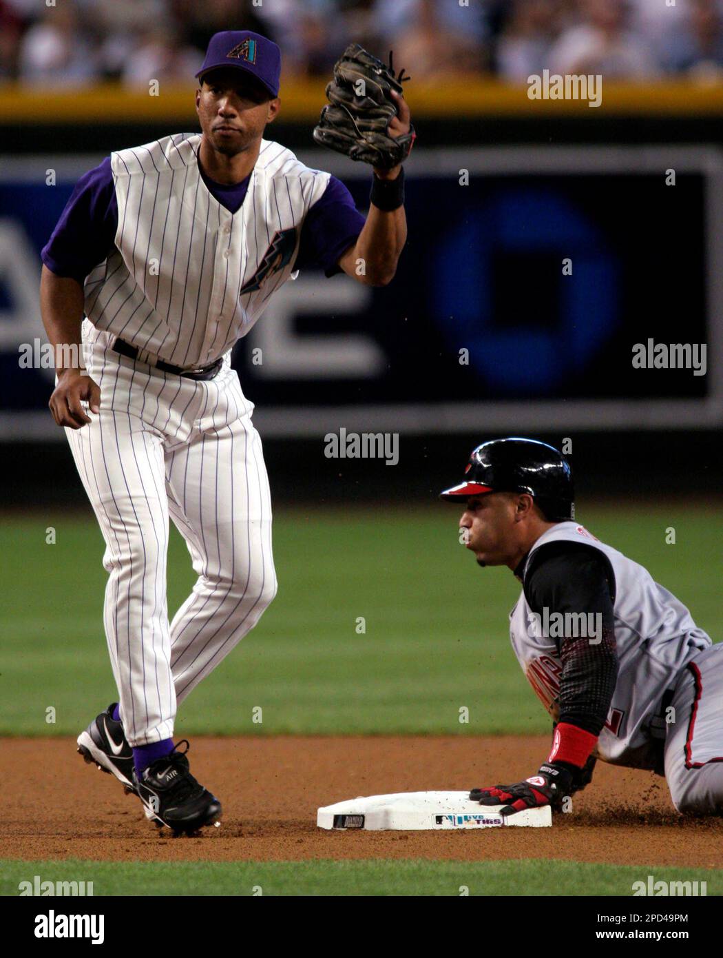 Arizona Diamondbacks shortstop Damion Easley, left, looks to the umpire, after tagging out Cincinnati Reds' Felipe Lopez, right, who was thrown out by catcher Chris Snyder, during the first inning of their baseball game, Sunday, May 7, 2006, in Phoenix.(AP Photo/Roy Dabner) Banque D'Images