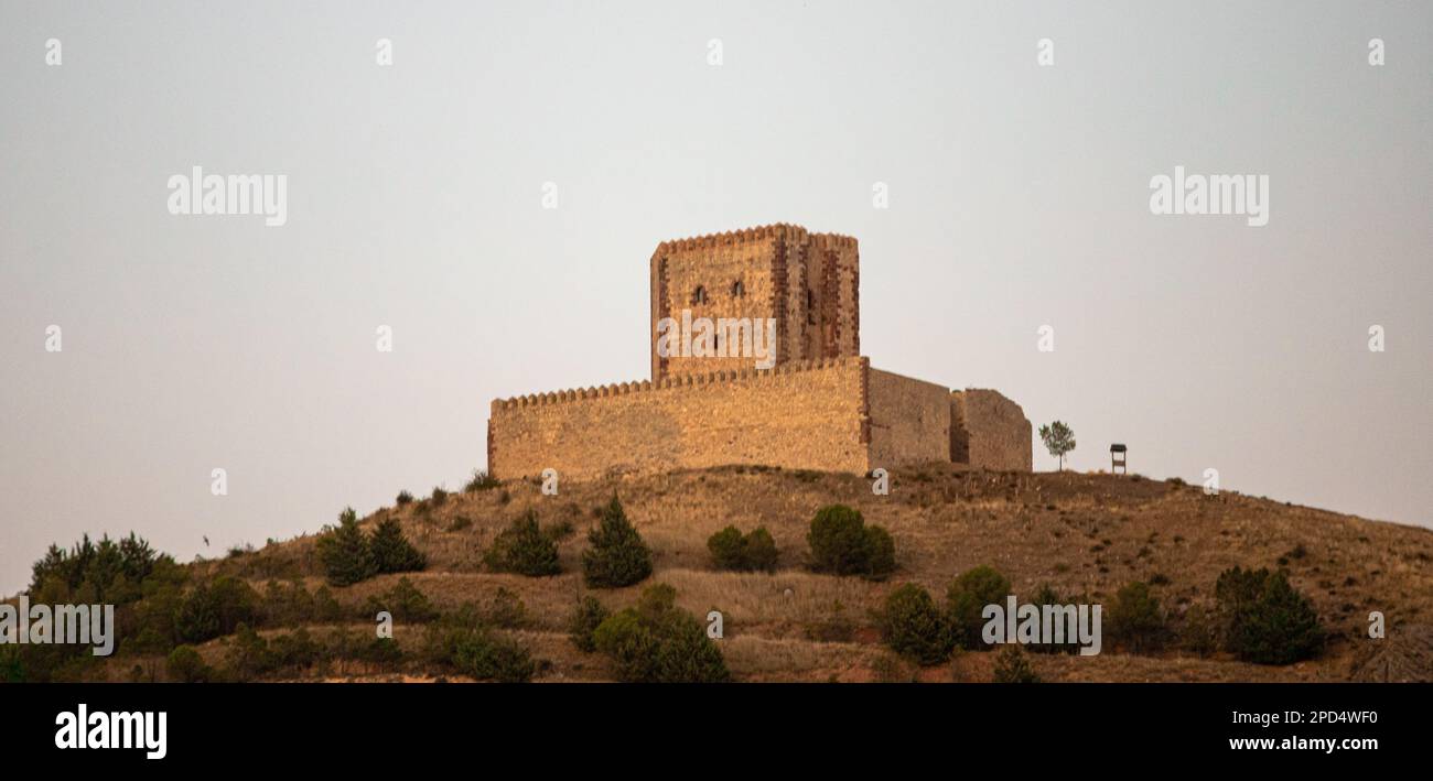 Un château sur une colline avec le soleil derrière lui Banque D'Images