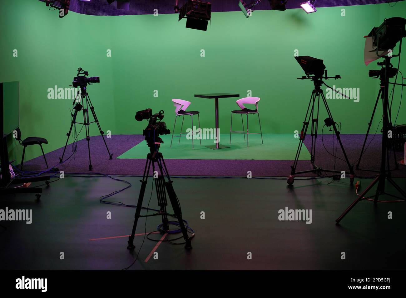 Intérieur moderne du studio de télévision Chroma Key avec écran vert, lumière, équipement de caméra et mobilier. Studio de tournage avec équipement professionnel. Banque D'Images