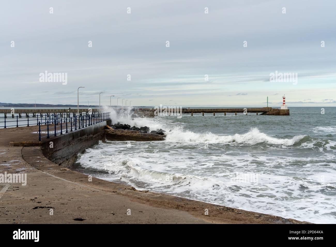 Vue sur les vagues qui s'écrasant au mur du port de la ville de Amble, Northumberland, Royaume-Uni Banque D'Images