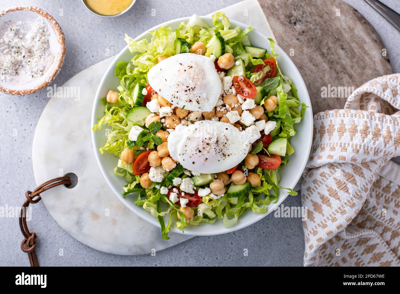 Salade de légumes frais avec pois chiches et feta nappés d'œufs pochés, idée petit déjeuner Banque D'Images