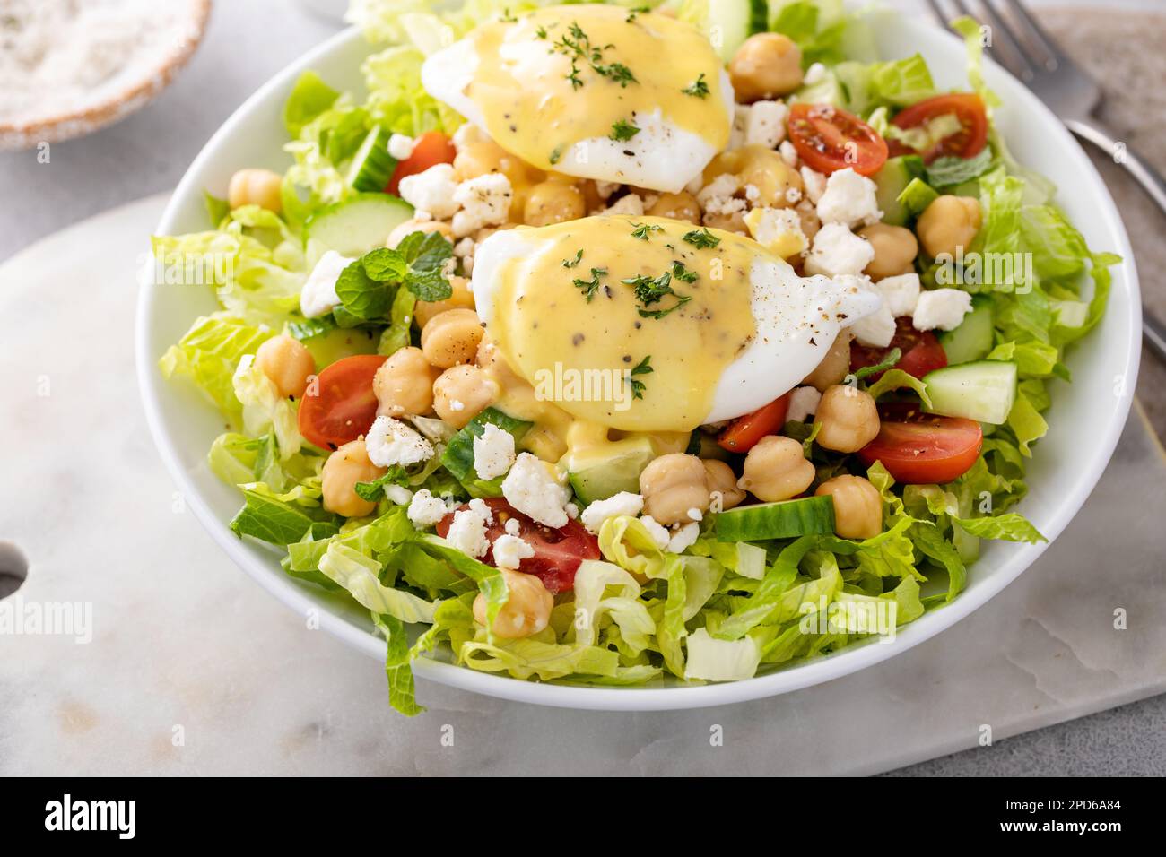 Salade de légumes frais avec pois chiches et feta nappés d'œufs pochés, idée petit déjeuner Banque D'Images