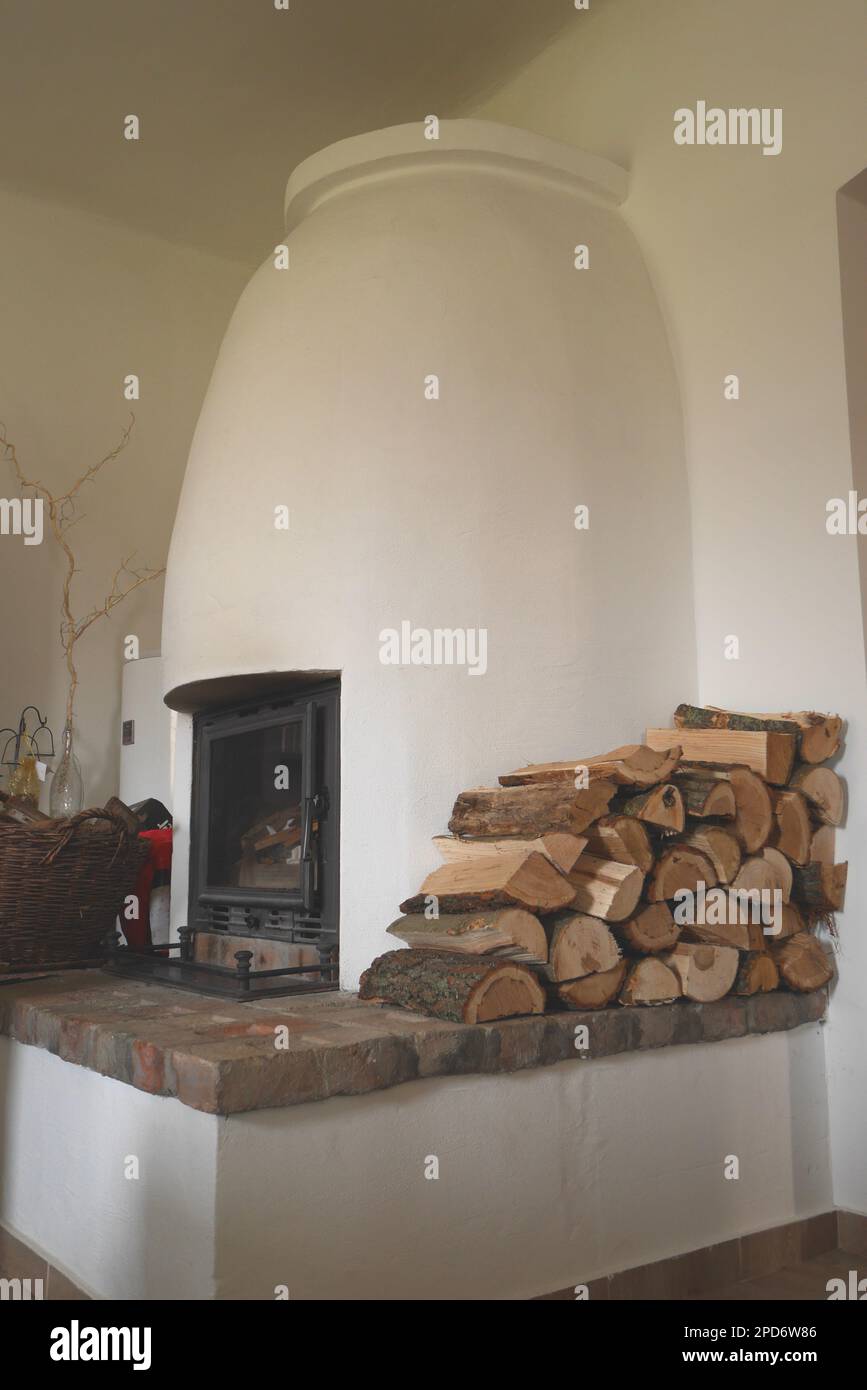 Poêle à bois blanc traditionnel avec une pile de rondins dans une maison paysanne, Hongrie Banque D'Images