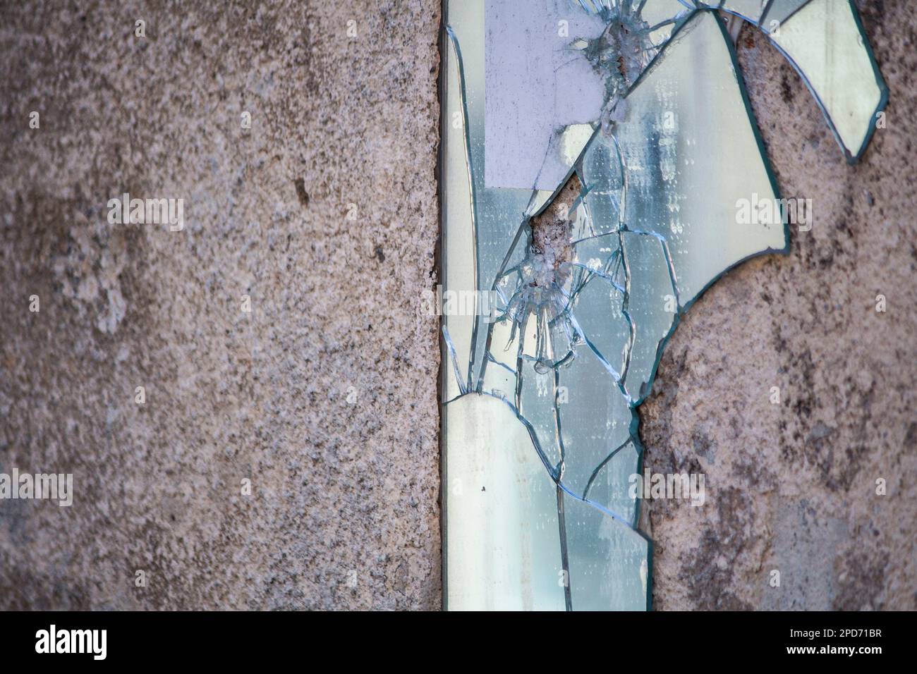 Un miroir brisé sur un mur industriel en béton Banque D'Images