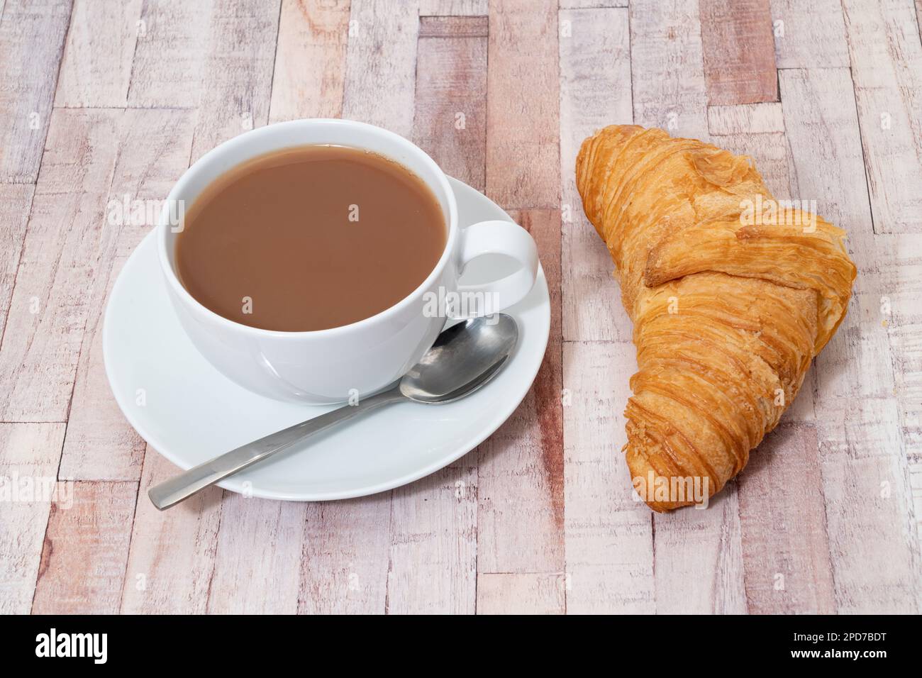Le petit-déjeuner se compose d'un croissant frais avec du beurre de lait et de la confiture de framboise et d'une tasse de thé Banque D'Images