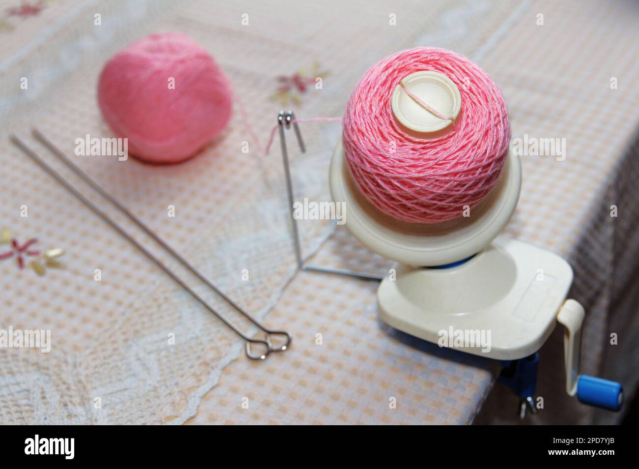 Processus d'enroulement du fil de laine rose de l'enchevêtrement à l'enroulement, à l'aide d'un corbillard sur la table Banque D'Images