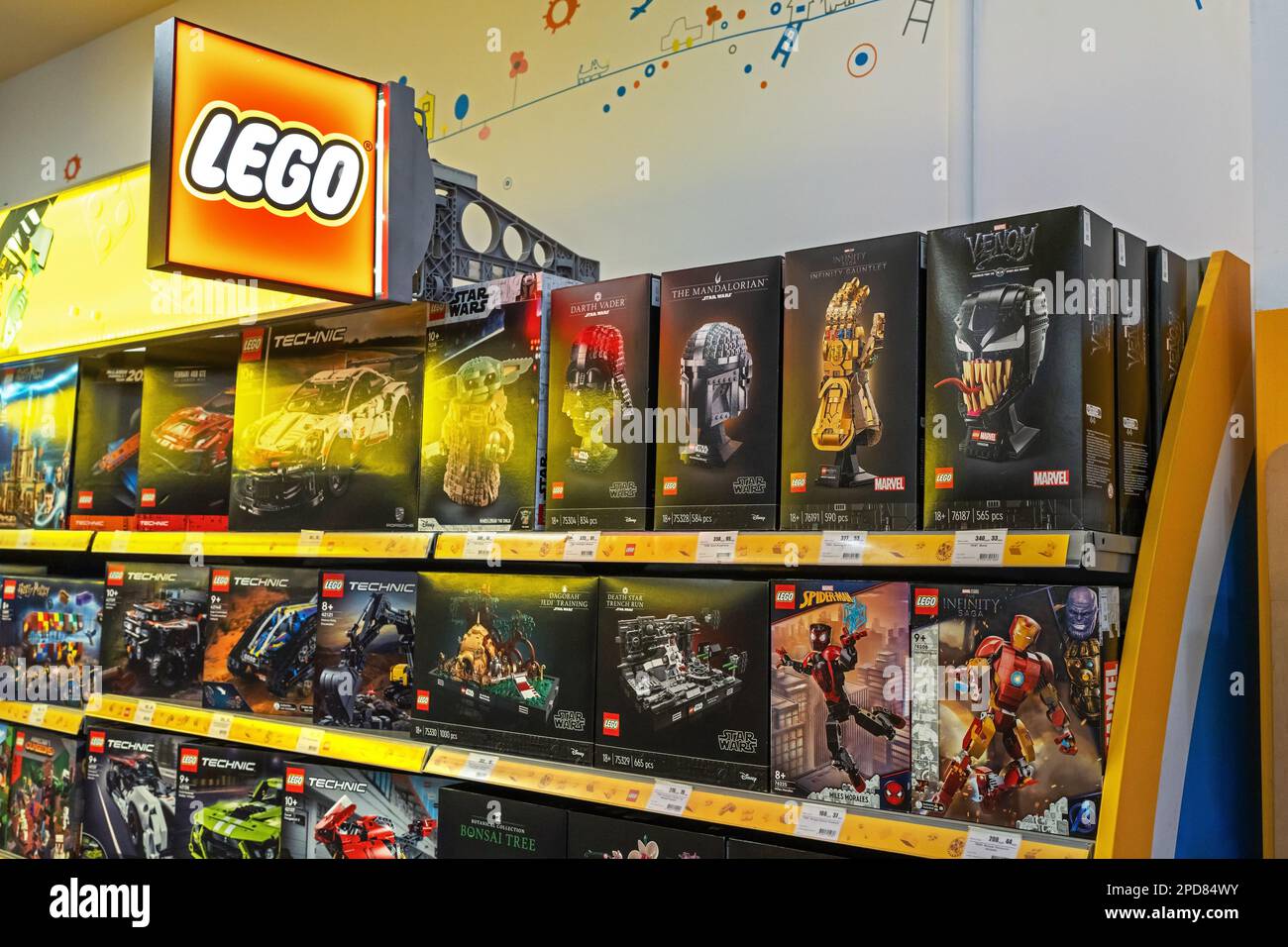 Un signe avec le logo Lego. Les jouets LEGO sont vendus dans un supermarché. Une sélection de jouets Lego emballés à vendre sur une étagère dans un magasin. Minsk, Bélarus, 2023 Banque D'Images
