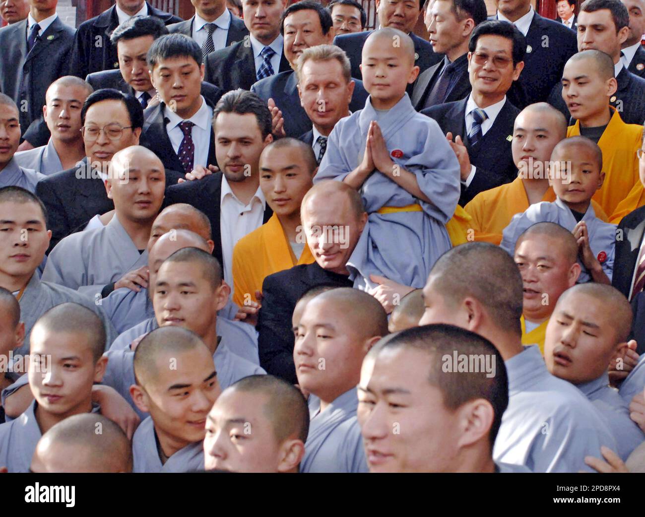 Russian President Vladimir Putin, center, holds a young monk on shoulder, as he is surrounded by a group of monks after watching their demonstration of Shaolin Kung Fu in Shaolin Temple in central China's Henan Province, Wednesday, March 22, 2006. Putin arrived here on Wednesday for a taste of Buddhism and martial arts. Established about 1,500 years ago, Shaolin is famed for the great combination of martial arts skill and Zen, a sect of Buddhism, that features long meditation sessions to purify the mind. (AP Photo/Xinhua News, Wang Song) Banque D'Images