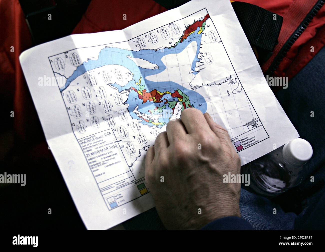 Mark Glover of the Humane Society International looks over an ice analysis for the Gulf of St. Lawrence as he and members of the Humane Society of the United States fly over the ice floes looking to observe harp seals in the Gulf of St. Lawrence Wednesday, March 22, 2006. The HSUS along with the International Fund for Animal Welfare (IFAW) and media have arrived in the area to witness the annual harp seal hunt which is expected to begin sometime this week. (AP Photo/CP, Jonathan Hayward) Banque D'Images