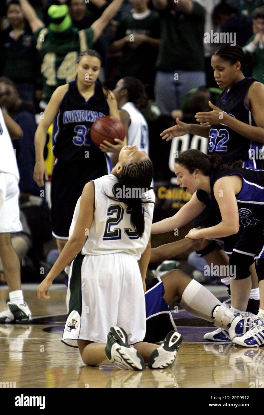 Lauren Bell, 23, from Sacred Heart Cathedral, of San Francisco, drops to her knees, while members of Windward of Los Angeles, background, celebrate the end of regulation play tied, sending it into overtime of the Girls Division IV CIF Championship basketball game Friday, March 17, 2006, in Sacramento, Calif. Sacred Heart Cathedral beat Windward 66-56 in overtime. (AP Photo/Rich Pedroncelli) Banque D'Images