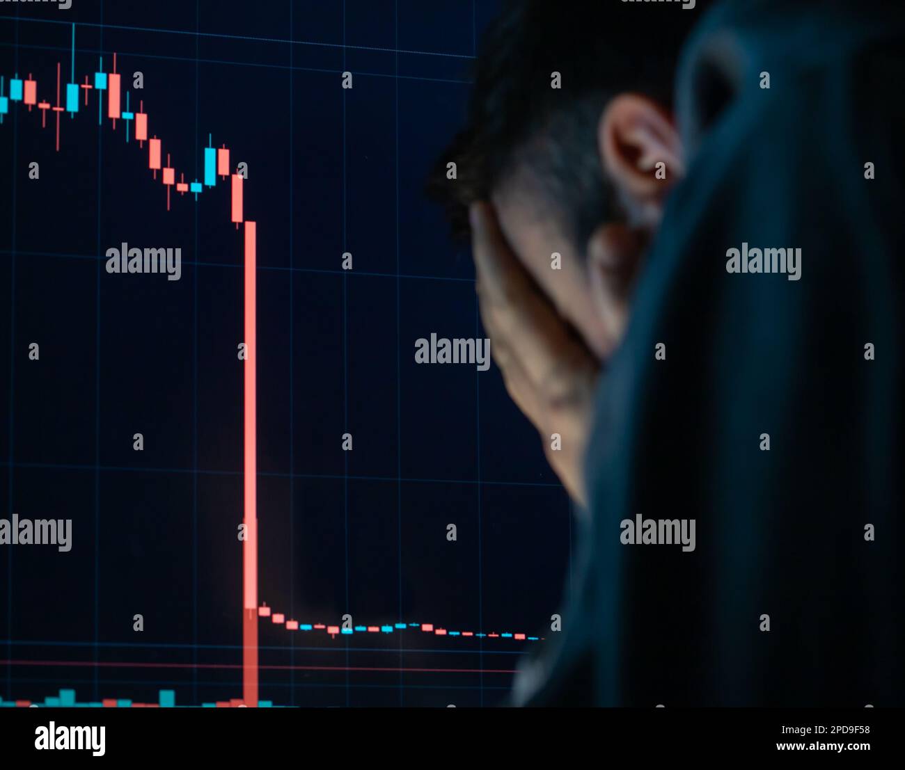 Un homme frustré et déprimé qui tient la tête dans les mains choqué quand la Bourse mondiale baisse. Banque D'Images